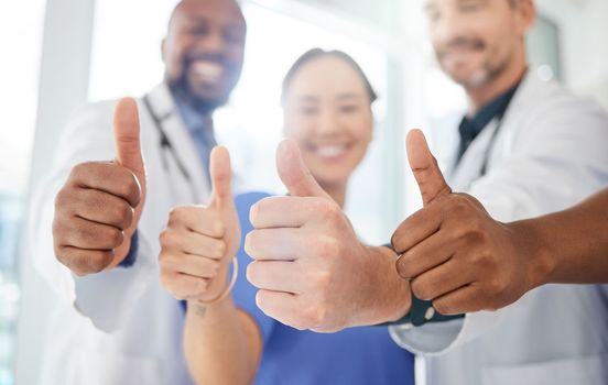 They stand first in the medical world. a group of doctors showing a thumbs up in a office.