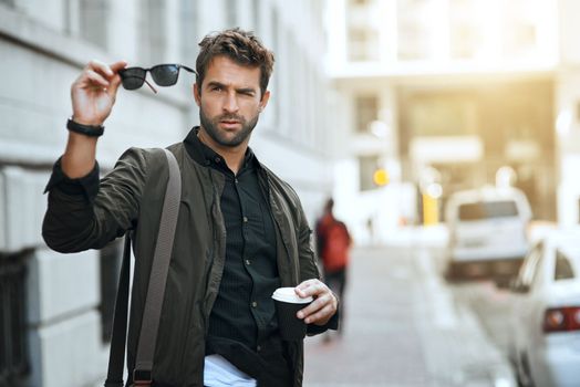 Nothing will impair his vision. a handsome young man checking his sunglasses while traveling through the city.