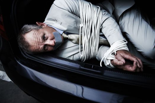 Fearing for his life. A bound and gagged businessman lying in the trunk of a car.