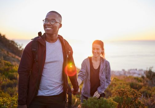 Interracial couple, workout and hiking exercise in sunset on a mountain as morning fitness in nature. Happy people, man and woman in a relationship training for health and wellness together