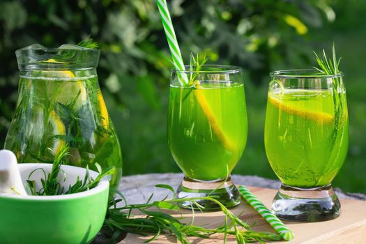 Homemade summer refreshing tarragon lemon drink on patio table