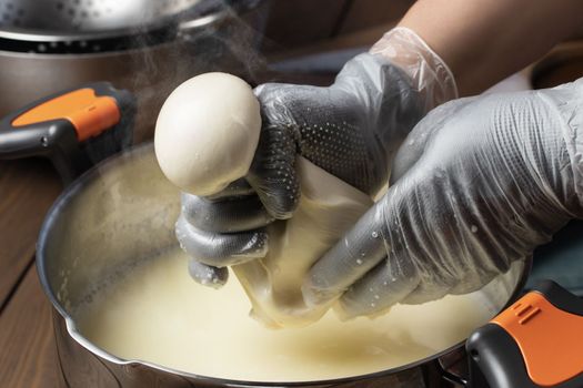 Making mozzarella cheese. Forming balls from cheese curd
