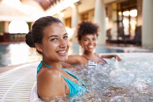 The best way to spend a vacation. two gorgeous young women in a jacuzzi.
