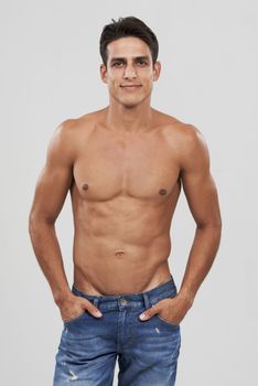 Loving his body. A handsome young shirtless man posing in studio.