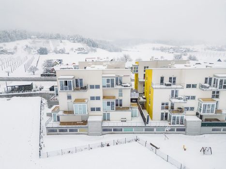 Aerial view of new modern apartment complex in the middle of snowy countryside in Slovenia