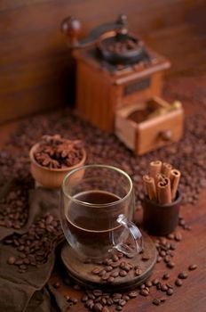 Tasty steaming espresso in cup with coffee beans. View from above. Dark background