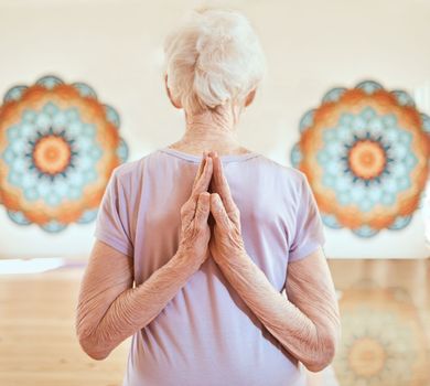 Elderly woman in pose for yoga, flexibility and fitness in studio, hands with arms stretching and vitality in old age. Balance, exercise and chakra with peace and body training and wellness.