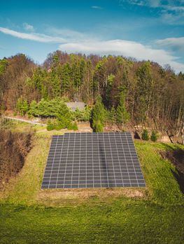 Vertical view of solar panels stacked on a sunny side of the hill in the country side