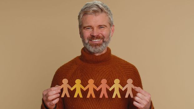 Man showing multiracial different skin color human shape cut out of paper against racism community