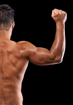 Is this your goal. Rear-view shot of a muscular young man flexing his muscles against a black background.