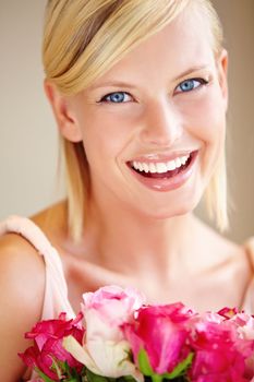 Flowers, portrait and happy woman in a studio with roses for valentines day, anniversary or romantic event. Happiness, smile and female from canada with a pink floral bouquet by a nude background.