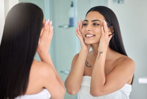 Get your glow back. a young woman doing her skincare routine in a bathroom at home.