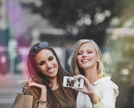 Shopping spree selfie. two young women taking a selfie while out shopping in the city.