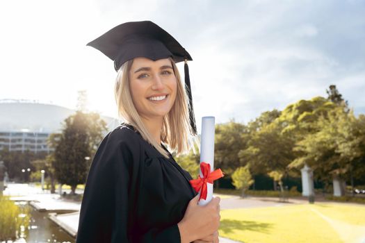 Woman, student and portrait smile of graduate with achievement in higher education. Happy female academic smiling in graduation holding certificate, qualification or degree for university scholarship