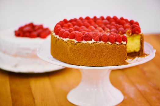 Dare yourself to have a bite. a delicious cheese cake topped with cream and fresh raspberries.
