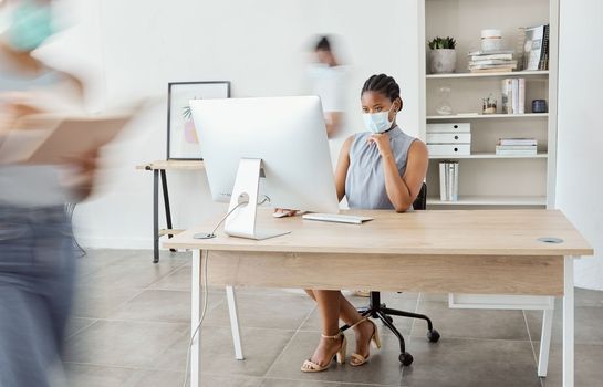 Covid, office and black woman with busy people with face mask for health safety in workplace. Corporate, business and female worker using internet, working on computer and focused at desk in pandemic.