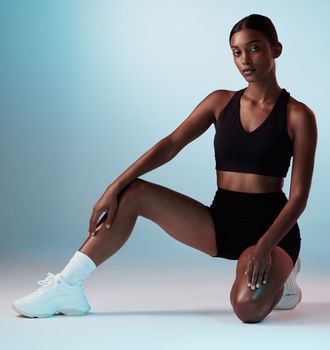Fitness, athlete and portrait of young woman in sportswear in a studio background for health. Wellness, active and focus with a fit, strong Indian woman posing in trendy sport clothing on backdrop.