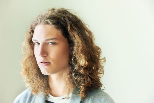 Hes got hidden depths. Portrait of a casual young man with long, curly hair.