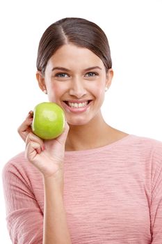 Health, apple and smile with portrait of woman for nutrition, diet and weight loss choice. Fiber, food and vitamins with isolated face of girl eating fruit for wellness, organic and natural in studio