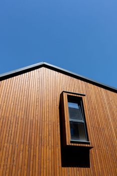 Wooden plank gabled roof on a new modern house with window, copy space