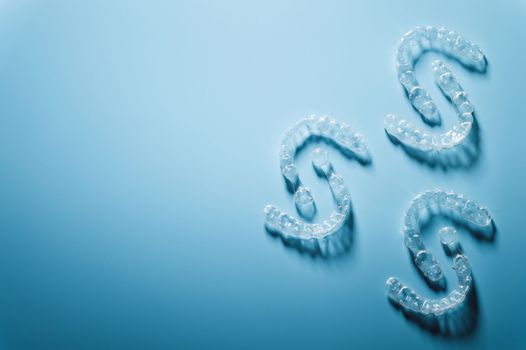 plastic braces in the shape of a pattern lie on a blue background, dental care and health