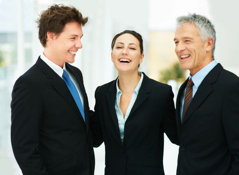 Workplace laughter. a group of businesspeople laughing together in an office.