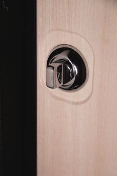 Close up of stylish silver chrome door handle on modern interior door. Stylish light brown door with frosted glass inserts. Concept of catalog of door handles for furniture store