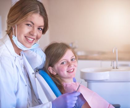 Shes specially trained for childrens dental needs. Portrait of a female dentist with her young patient