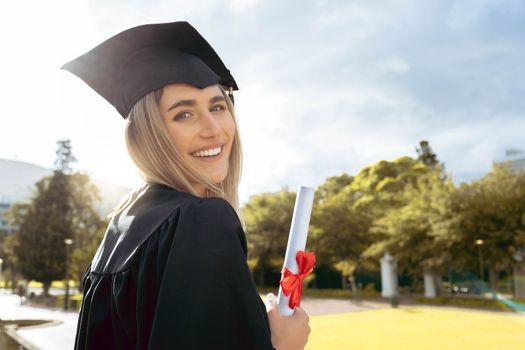 Woman, student and smile for graduation, diploma or achievement in higher education. Portrait of happy female academic learner holding certificate, qualification or degree for university scholarship