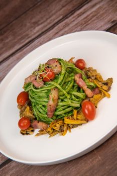 Recipe for spaghetti with spinach cream and smoked bacon, tomatoes and chanterelle mushrooms