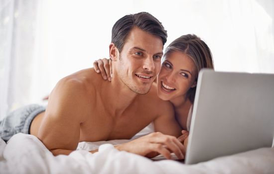 Couple with laptop, streaming movie and relax at home with technology, happy and fun together with film website Love, commitment and relationship with man and woman in bedroom with subscription