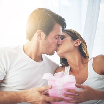 Couple kiss with gift, love and care, thank you for present on Valentines day, date with commitment at home. Luxury, gratitude and romance in partnership, man and woman celebrate with intimacy
