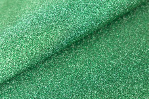 Green shiny glitter wave paper texture. Glow luxurious fabric. Light green color. Empty space.