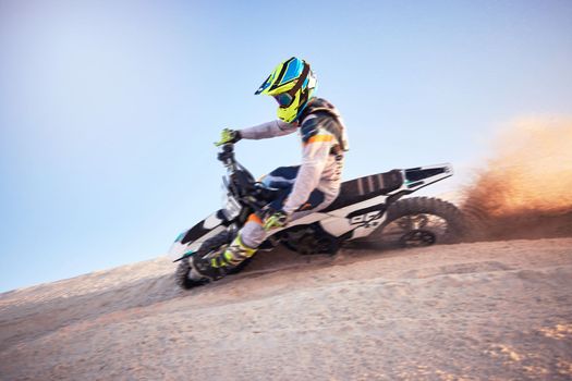 Motorcycle, athlete and sports outdoor, fitness and riding in desert with stunt for extreme sport, fast and safety helmet. Challenge, power and biking exercise, person training and dirt bike rally