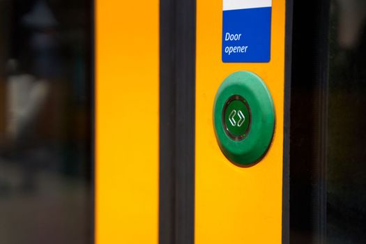 A close-up of an external button for opening doors in a tram