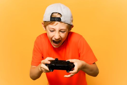 a gamer boy holds a gamepad in his hands and actively presses the emotion buttons in the game