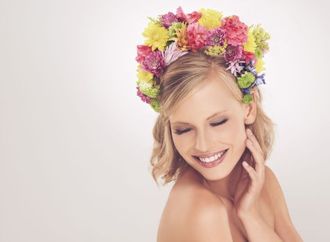 Her beauty is true. A young woman posing with her eyes shut and flowers in her hair