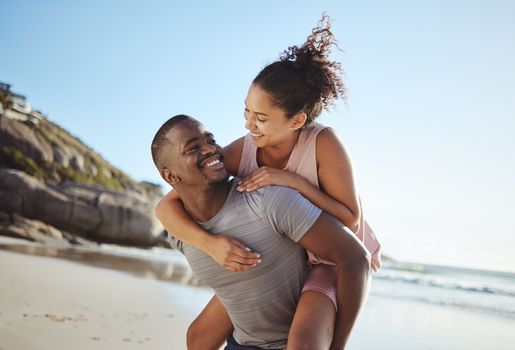 Love, piggy back and black couple on beach walking, smile and happy together, for bonding and outdoor. Romantic, man carry woman or loving on seaside vacation, holiday and romance for relationship