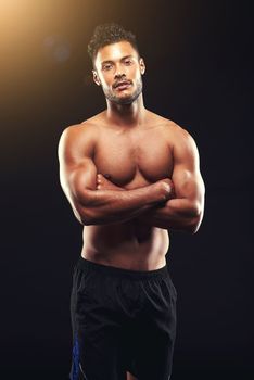 Staying fit and strong. Studio shot of a fit young man isolated on black.