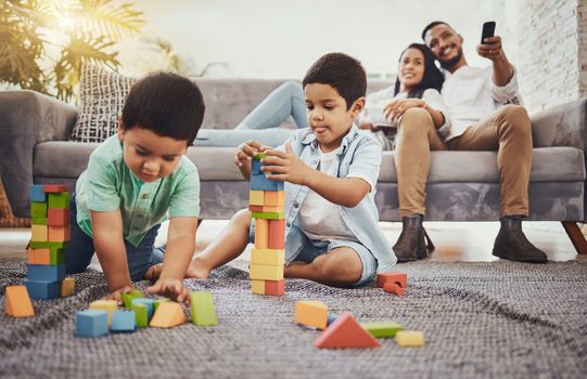 Building blocks, family or children learning for development growth with mother and father relaxing watching tv. Education, siblings or young boys playing fun toys or games for kids at home together