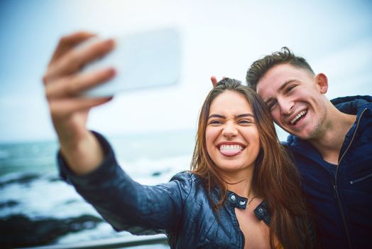 Celebrate love with a selfie. a happy young couple taking a selfie outdoors.