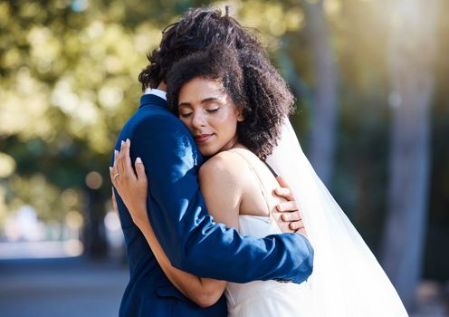 Care, hug and wedding bride with groom at romantic outdoor marriage event celebration together. Partnership, commitment and trust embrace of married interracial couple in nature with bokeh.
