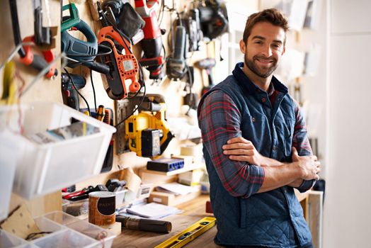 Hes prepared for any project. Portrait of a handsome young handyman standing in front of his work tools.