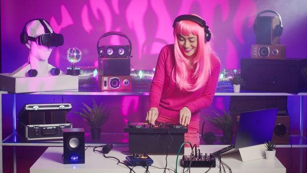 Musician with headset standing at dj table having fun