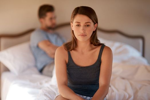 I think its time for me to leave. a young woman sitting on the edge of the bed after arguing with her husband.