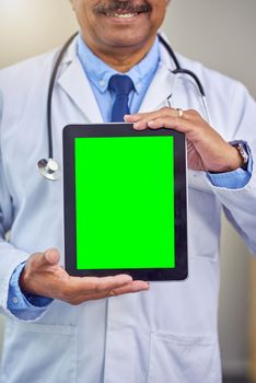 Medical information is part of the process. an unrecognizable male doctor holding up a digital tablet in front of him while standing inside of a hospital during the day.