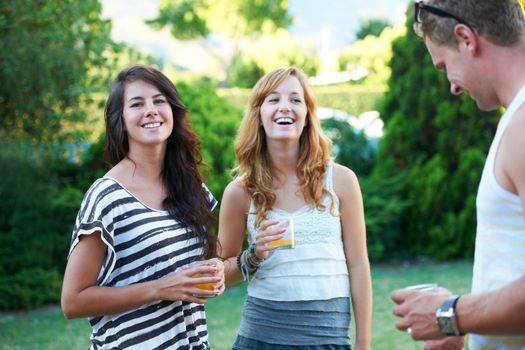 Enjoying good company and great weather. Young teens enjoying a social gathering outdoors with a laugh and a smile - portrait.