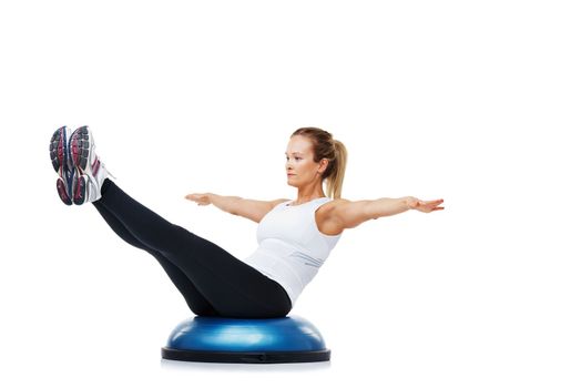 Striving for physical fitness. A young woman balancing on a bosu-ball.