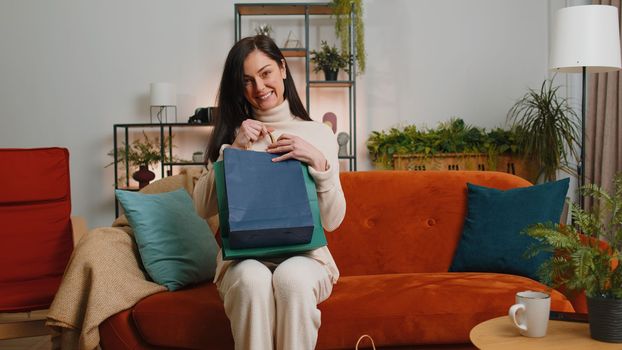 Happy young woman shopaholic consumer came back home after online shopping sale with bags at home