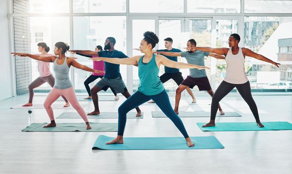 Yoga instructor, exercise class and fitness people in warrior ir stretching for health and wellness. Diversity men and women group together for workout, training or pilates for healthy lifestyle
